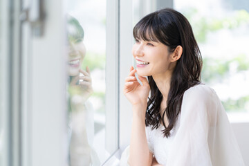 リビングでスキンケアをするミドルの女性