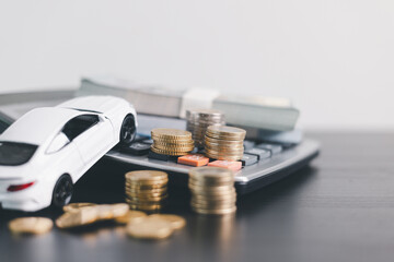 White car model with open door surrounded by stacked coins, symbolizing auto loan, car finance,...