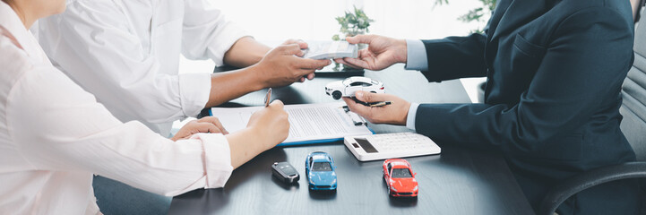 Panorama view of car loan agreement signing with dealer presenting vehicle model, customer using...