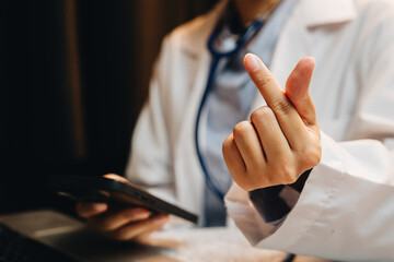 Healthcare professional showing hand gesture while using smartphone in a modern medical office environment