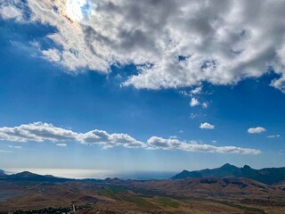 Scenic view of a mountain landscape and blue skies with clouds.