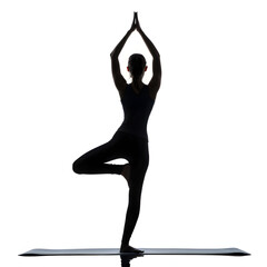 Fototapeta premium Serene Yoga Silhouette: A lone figure gracefully performs the Tree Pose, embodying inner peace, balance, and mindful practice. Witness the elegance of the form against the backdrop of tranquility.