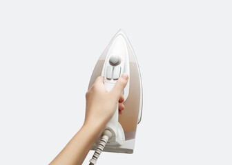 Hand holding an iron, ready to iron clothing