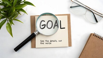 Magnifying Glass Focusing On Goal Written On Notepad
