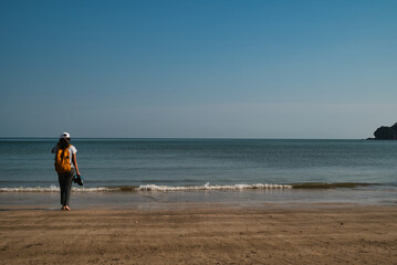 Girl hiking alone along the shore of Bako National Park beach on the island of Borneo, Malaysia.