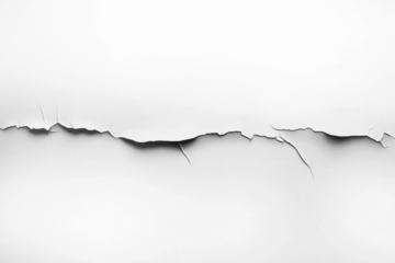 Close-up of a jagged horizontal crack in a white surface, revealing texture and depth with subtle shadows.