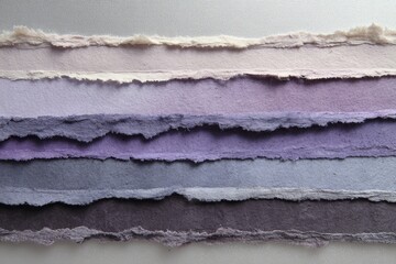 Layered sheets of handcrafted paper, exhibiting a captivating gradient of muted violet and lavender tones, with textured edges.