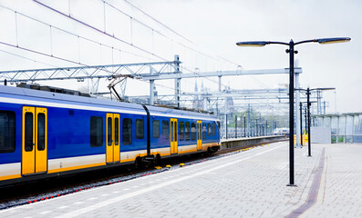 Fototapeta premium A local blue train no logo departs from the station in the Netherlands.