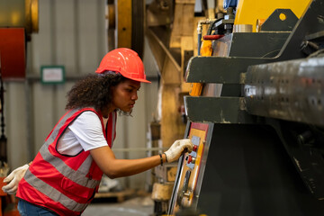 Factory workers are rolling metal sheets. Worker intend to work in a heavy industrial factory looking and control machine.