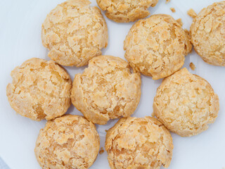 Assortiment de petits choux croustillants dorés servis sur une assiette blanche, photographie culinaire lumineuse d’un buffet lors d’une soirée d’entreprise à Paris.