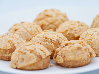 Assortiment de petits choux croustillants dorés servis sur une assiette blanche, photographie culinaire lumineuse d’un buffet lors d’une soirée d’entreprise à Paris.