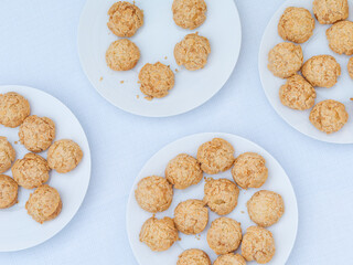 Assortiment de petits choux croustillants dorés servis sur une assiette blanche, photographie culinaire lumineuse d’un buffet lors d’une soirée d’entreprise à Paris.