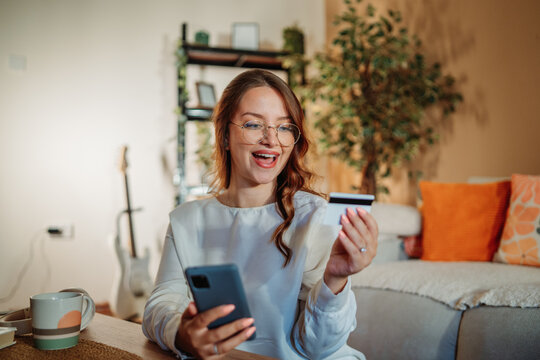 Young caucasian woman buying online on smart phone using credit card
- Powered by Adobe
