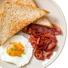 Classic breakfast plate with fried egg crispy bacon and toast. 