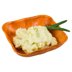 Creamy potato salad in an orange bowl with green garnish. 