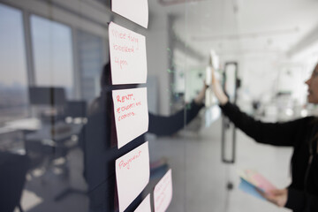 Obraz premium Close up of paper sticky notes on training glass board