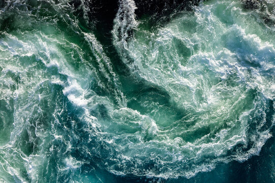 Blue waves of water of the river and the sea meet each other during high tide and low tide.