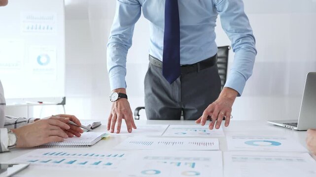 Business team professionals working together on financial reports and performance graphs during a strategy session, teamwork, planning, and corporate growth among successful people - Powered by Adobe