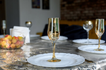 Table setting with gold glasses, fruit and white plates