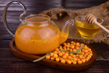 Sea buckthorn tea with honey in a teapot. A vitamin-rich drink for colds.
