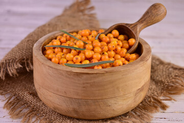 Sea buckthorn in a wooden bowl. Close-up.	