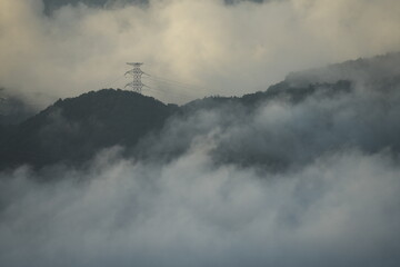 日本の秋の山々にかかる雲海と鉄塔