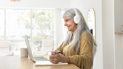 Cheerful senior student woman taking online training course