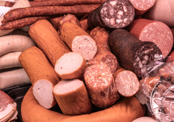 variety of sausages and cold cuts displayed in butcher shop counter