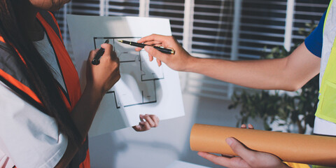 Closeup of team of industrial engineers meeting analyze machinery blueprints consult project on table in manufacturing factory. Working in manufacturing plant or production plant.
