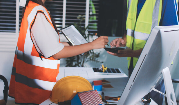 Closeup of team of industrial engineers meeting analyze machinery blueprints consult project on table in manufacturing factory. Working in manufacturing plant or production plant. - Powered by Adobe