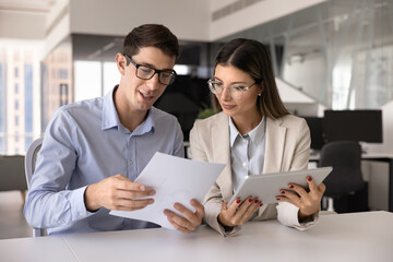 Couple of serious Latin business colleagues discussing paper report