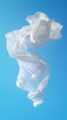 Fototapeta premium Floating white fabric dances against a clear blue sky. Weightless movement, purity, and airy elegance are conveyed.