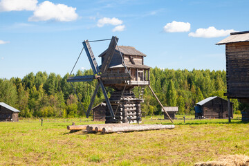 Fototapeta premium Historic Wooden Windmill with Large Blades under Blue Sky