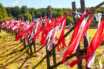 Wooden fence decorated with red and white ribbons at folk festival