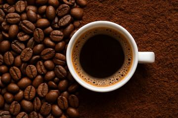 Cup of black coffee with coffee beans and ground coffee — top view
