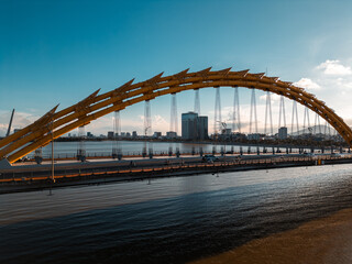 Golden Dragon Bridge over Han River in Da Nang at sunset, Iconic Vietnamese landmark spanning urban...