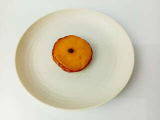 Kue Lumpur or Mud cake is a snack made from coconut milk, potatoes, wheat flour, and eggs as the main ingredients, served on a round plate.