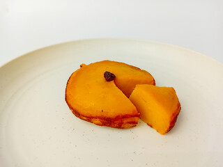 Kue Lumpur or Mud cake cut into pieces. Snack made from coconut milk, potatoes, wheat flour, and eggs as the main ingredients, served on a round plate.