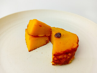 Kue Lumpur or Mud cake cut into pieces. Snack made from coconut milk, potatoes, wheat flour, and eggs as the main ingredients, served on a round plate.