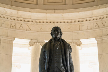 The statue of Thomas Jefferson stands inside the memorial, surrounded by engraved marble walls and Ionic columns.