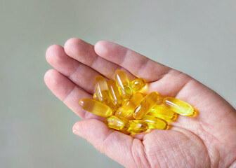 Omega 3 capsules on a woman's palm.
