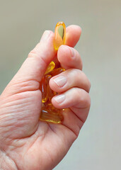 Omega 3 capsules in a woman's hands.