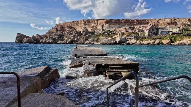 Wavees breaking on the shore oposite Popeye Village, Malta. High quality 4k footage