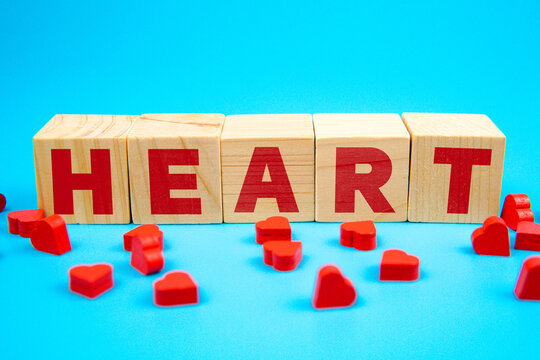 Wooden cubes spelling HEART with red hearts on blue background, symbolizing love, romance, emotion, and affection for Valentine or relationship concept. - Powered by Adobe