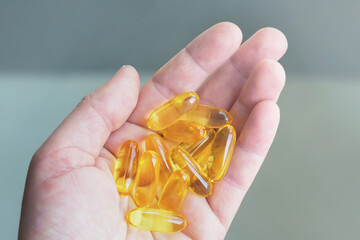 Omega 3 capsules on a woman's palm.