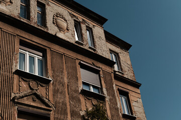 Old weathered building facade with decorative details and peeling plaster in Belgrade, Serbia