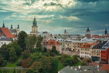 Widok na Lublin z wieży zamku w słoneczny dzień. Panorama Starego Miasta z charakterystycznymi kamienicami, wieżami i dachami, otoczona zielenią. © BMC