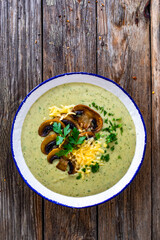 Creamy mushroom soup on wooden table. Top view