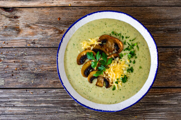 Creamy mushroom soup on wooden table. Top view