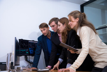 Group of four professionals giving thumbs up in modern office setting, showcasing teamwork and positivity. Their expressions reflect confidence and satisfaction with their work environment.